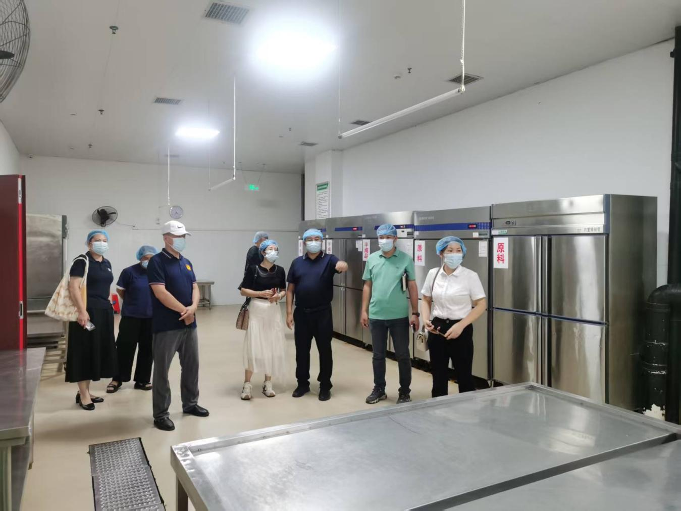 （和平副校长向来宾介绍食堂操作间布局）1